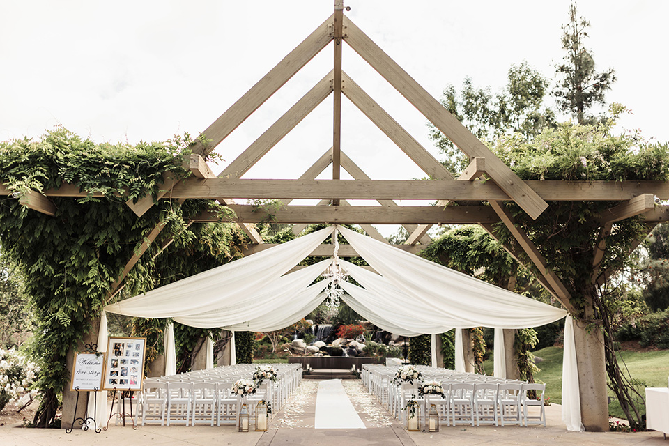  ceremony space under a geometric wooden gazebo with white linens