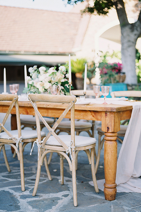 wooden table with white farm chairs and white table linens