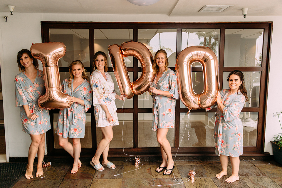  bride in a formfitting lace gown the bridesmaids in desert sunset colored gowns 