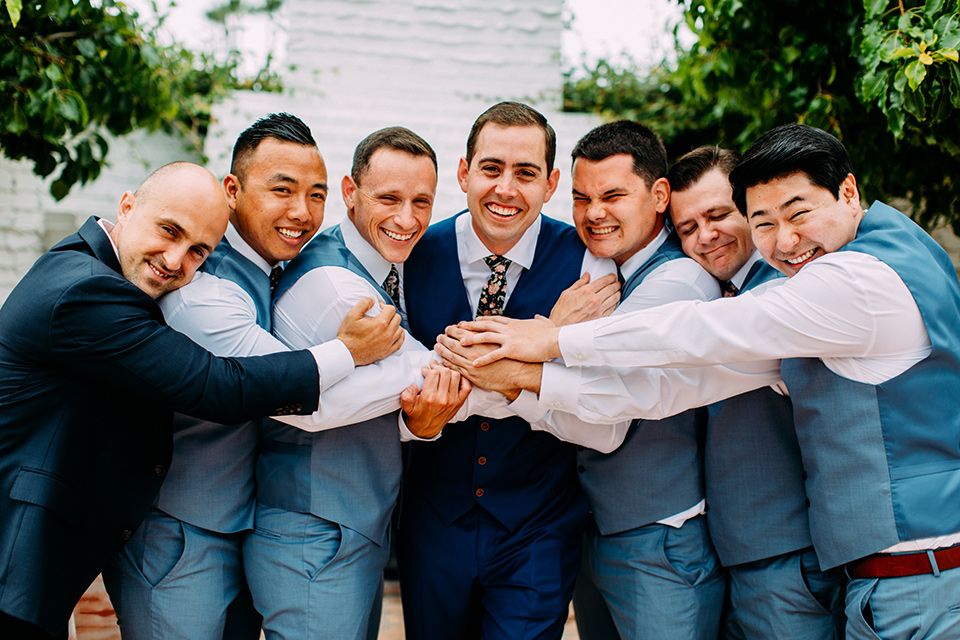  the groom in a blue suit and the groomsmen in light blue suits