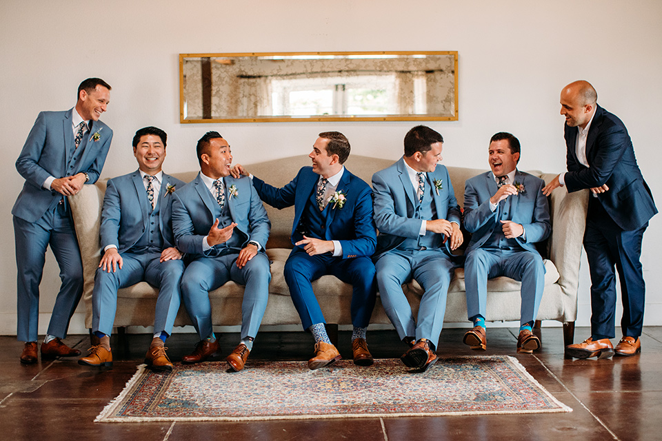  the groom in a blue suit and the groomsmen in light blue suits