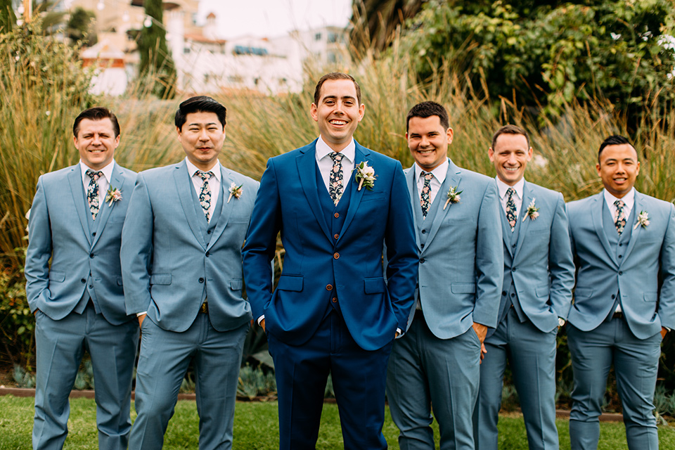  the groom in a blue suit and the groomsmen in light blue suits