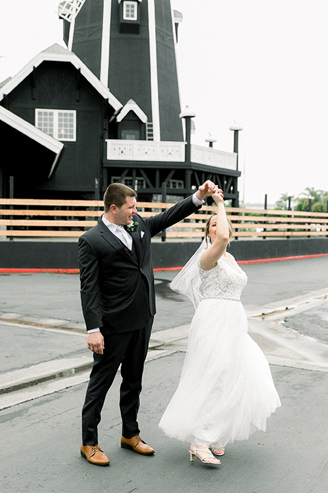  bride in a flowing gown with cap sleeves and the groom in an asphalt groom look
