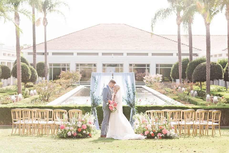 ceremony set up with wooden chairs and pink flowers