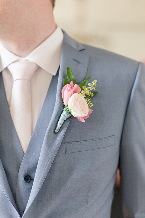  groom in a light blue suit with a pink boutonniere 