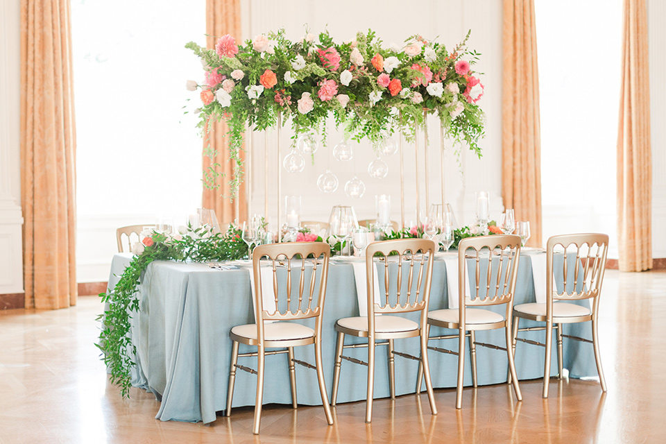 light blue table linens with white plates and gold flatware