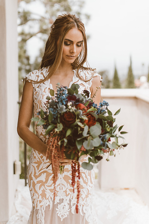  bride in a white lace gown with an illusion neckline and flowing train 