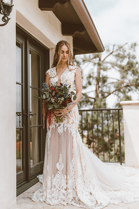  bride in a white lace gown with an illusion neckline and flowing train 