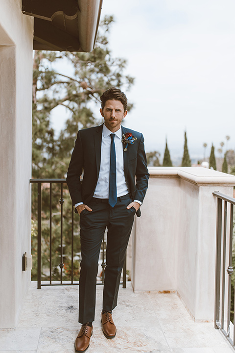  groom in a navy notch lapel suit with a deep teal long tie 