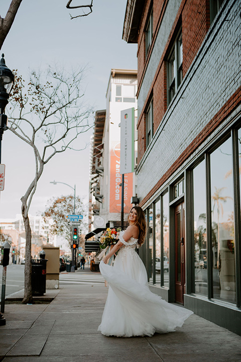  bride in a full skirt gown with an off the shoulder detail 