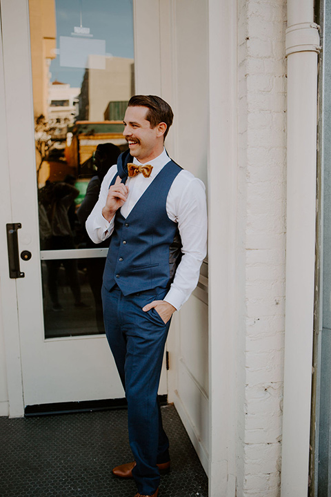  bride in a full skirt gown with an off the shoulder detail and the groom in dark blue suit and bow tie 