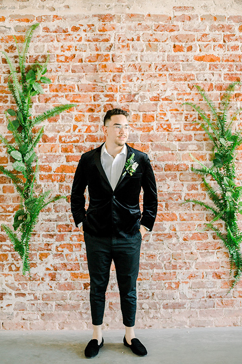  groom in a black velvet tuxedo with a cropped pant and bow tie