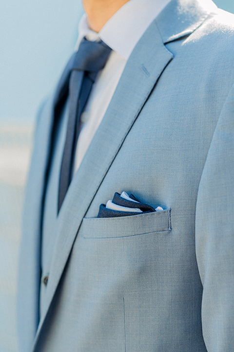  light blue suit with a navy long tie and pocket square