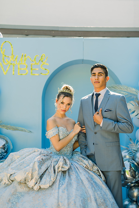  birthday girl in a light blue gown and a strapless neckline and the chambelanes in a light blue suit with a navy long tie