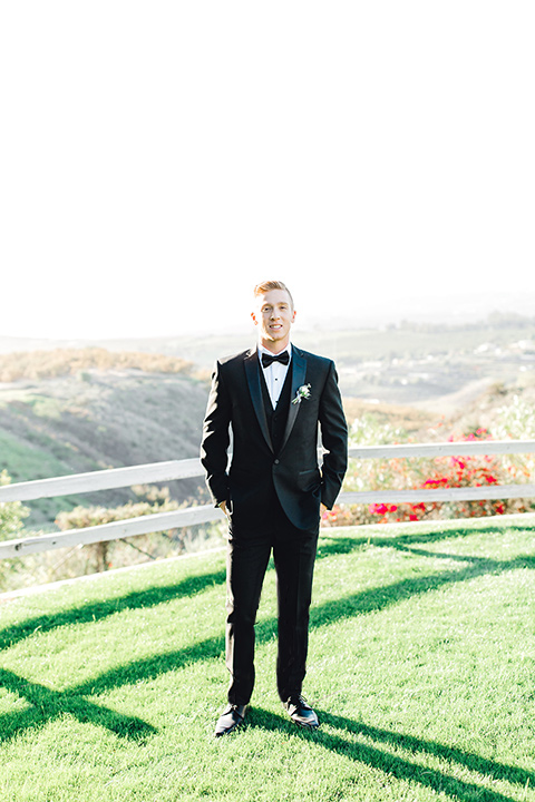  groom in a black tuxedo with a black bow tie 