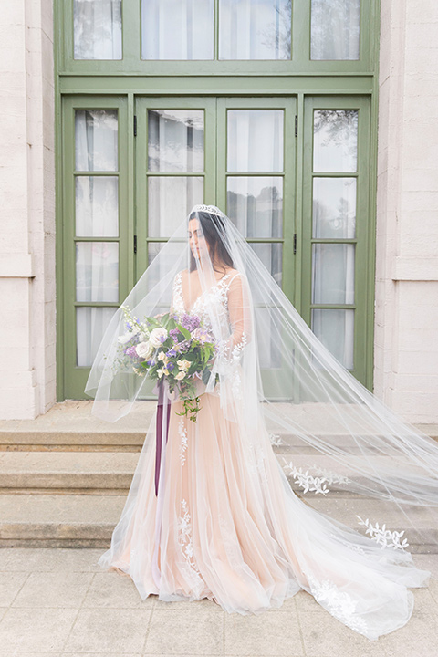  bride in a white lace ballgown with a sweetheart neckline and a regal looking crown