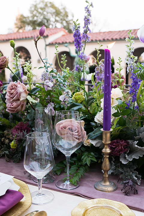  purple tall candles with green florals on the table 