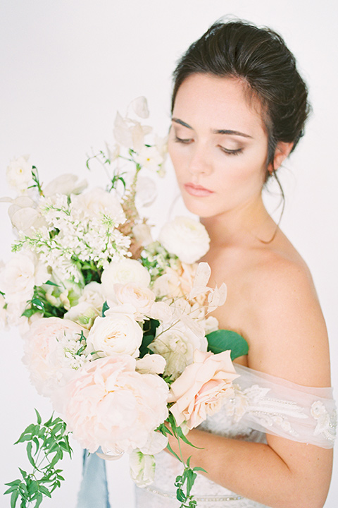  bride in a form fitting gown with an off the shoulder detail 