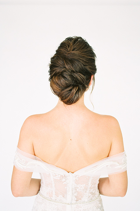  bride in a form fitting gown with an off the shoulder detail 