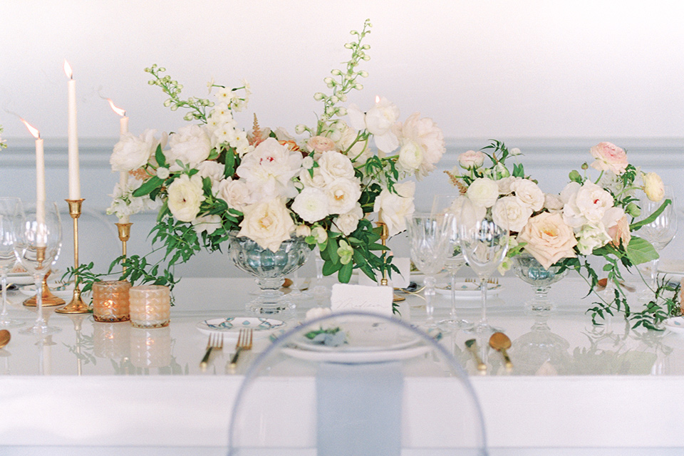  white tablescape with white chairs on it 