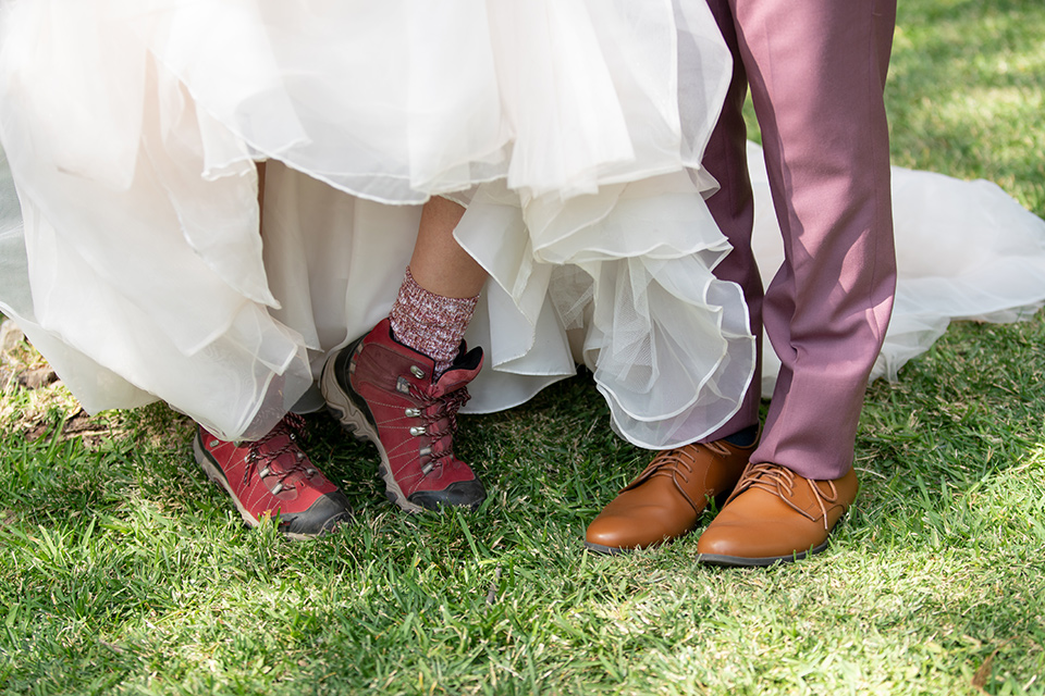  bride in a white ballgown with a deep-v neckline and crystal embellishments and the groom in a rose pink suit with a navy floral neck tie 