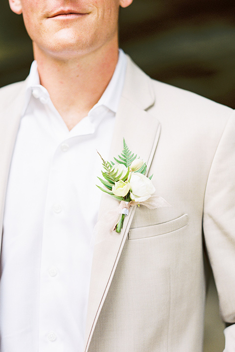  bride in a flowing blush and white gown with a silk style top and the groom in a tan suit with no tie and light brown shoes 