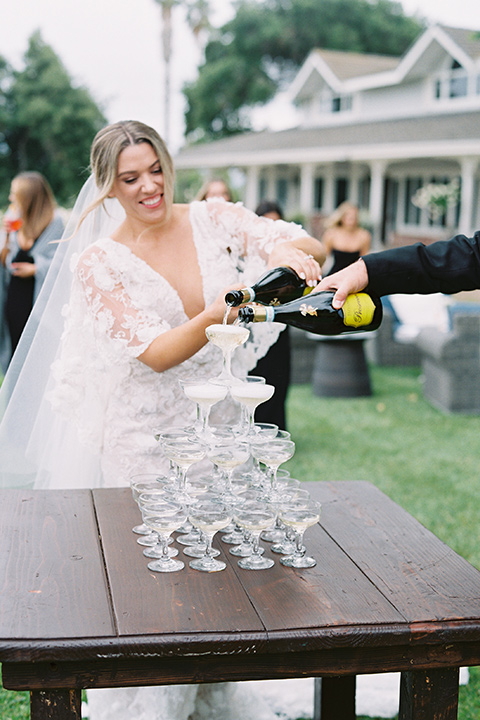  bride in a white gown with floral appliques and trumpet sleeves, the bridesmaids in black dresses in all different styles