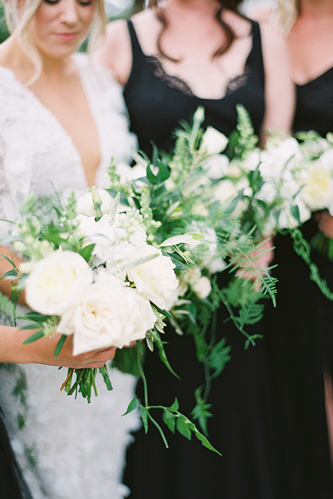  bride in a white gown with floral appliques and trumpet sleeves, the bridesmaids in black dresses in all different styles 