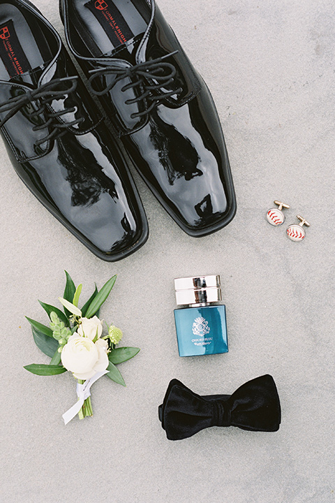  bride in a white gown with floral appliques and trumpet sleeves, the groom in a black tuxedo with black tie accessories 