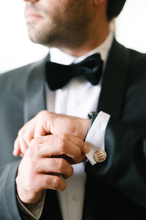  bride in a white gown with floral appliques and trumpet sleeves, the groom in a black tuxedo with black tie accessories 