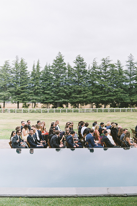  bride in a white gown with floral appliques and trumpet sleeves, the groom in a black tuxedo with black tie accessories