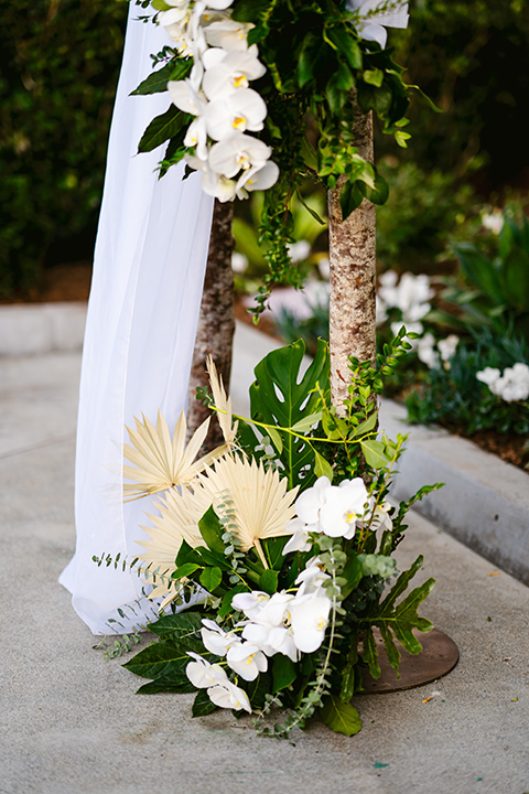 white florals and white linens at ceremony arch 