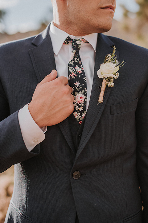 groom in a blue suit and a floral long tie