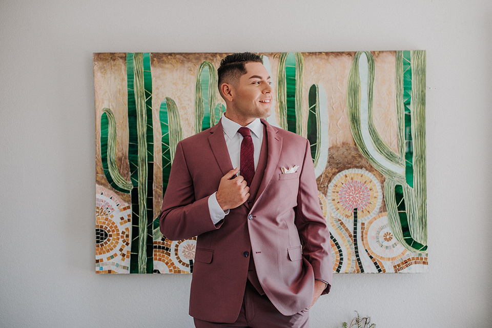  groom in a pink suit with a deep burgundy bow long tie 