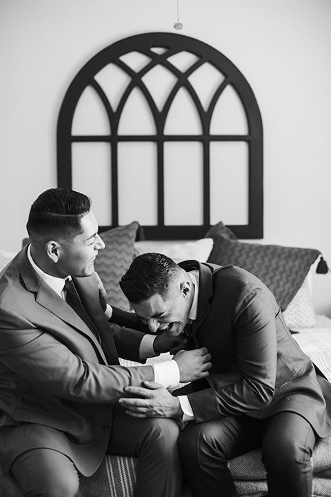 groom in a blue suit and a floral long tie and the other groom in a rose pink suit and a burgundy long tie