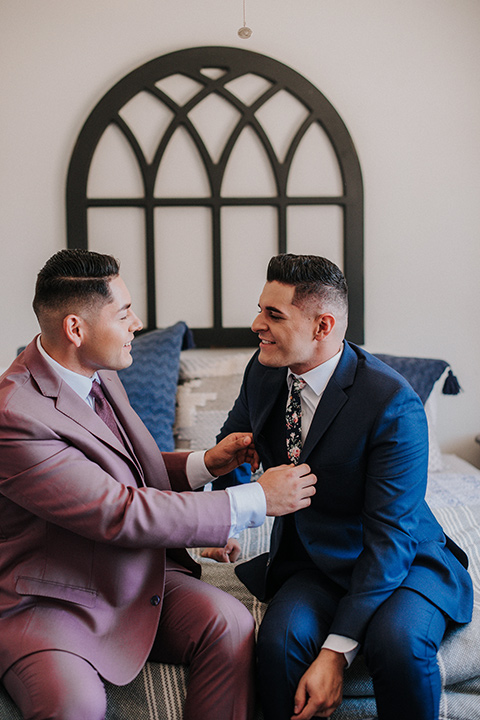 groom in a blue suit and a long floral tie and a pink suit with a long burgundy tie