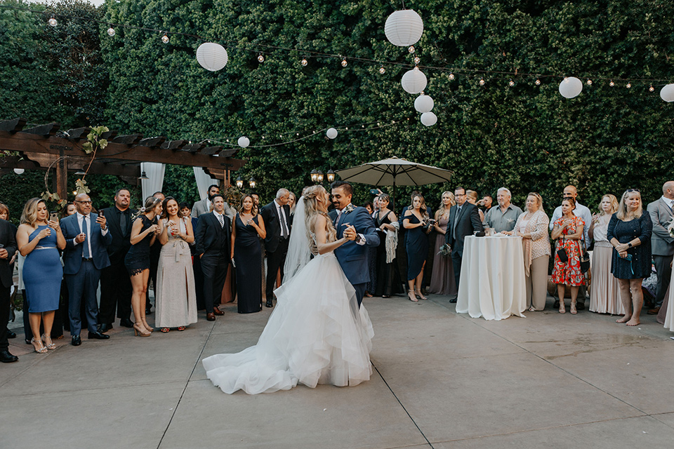 bride in a white ballgown and lace bodice detailing, the groom in a dark blue suit with a pink long tie.  The bridesmaids in pink dresses and groomsmen in light grey suits with dark blue vests