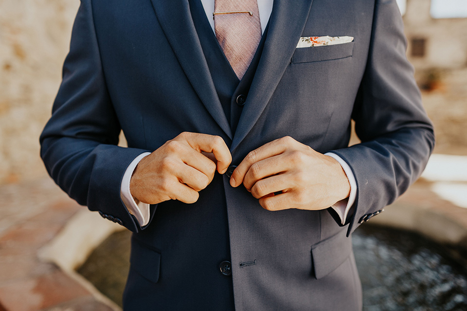 groom in a dark blue suit and a light pink long tie