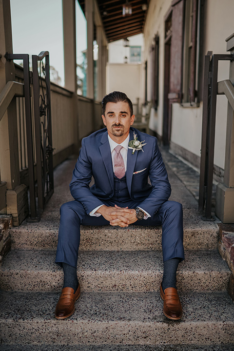 groom in a dark blue suit with a light pink suit