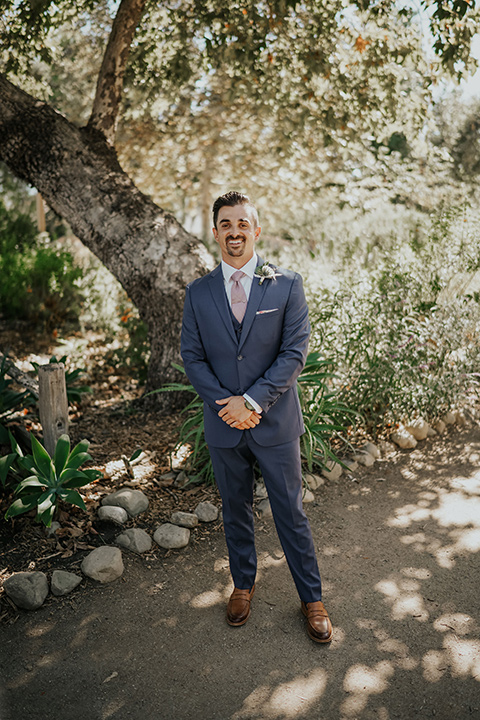 groom in a dark blue suit and light pink long tie