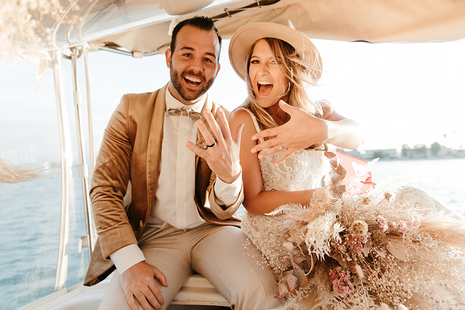  1970s golden hour boat elopement – couple on boat showing rings