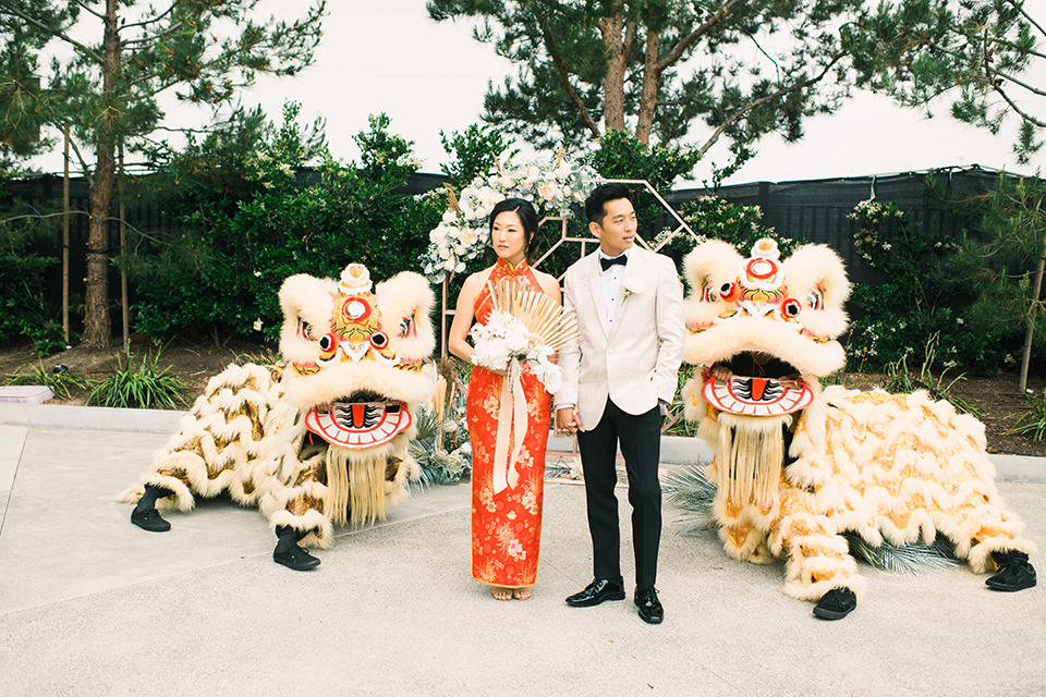  bride and groom in Chinese attire with lion dancers