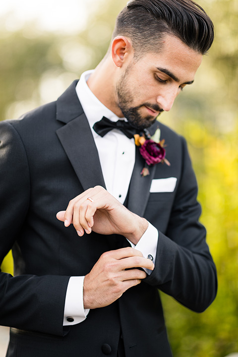  old world wedding at Allegretto Vineyard Resort – bride in a long gown with a cutout back design and the groom in black tuxedo with a black diamond bow tie at ceremony