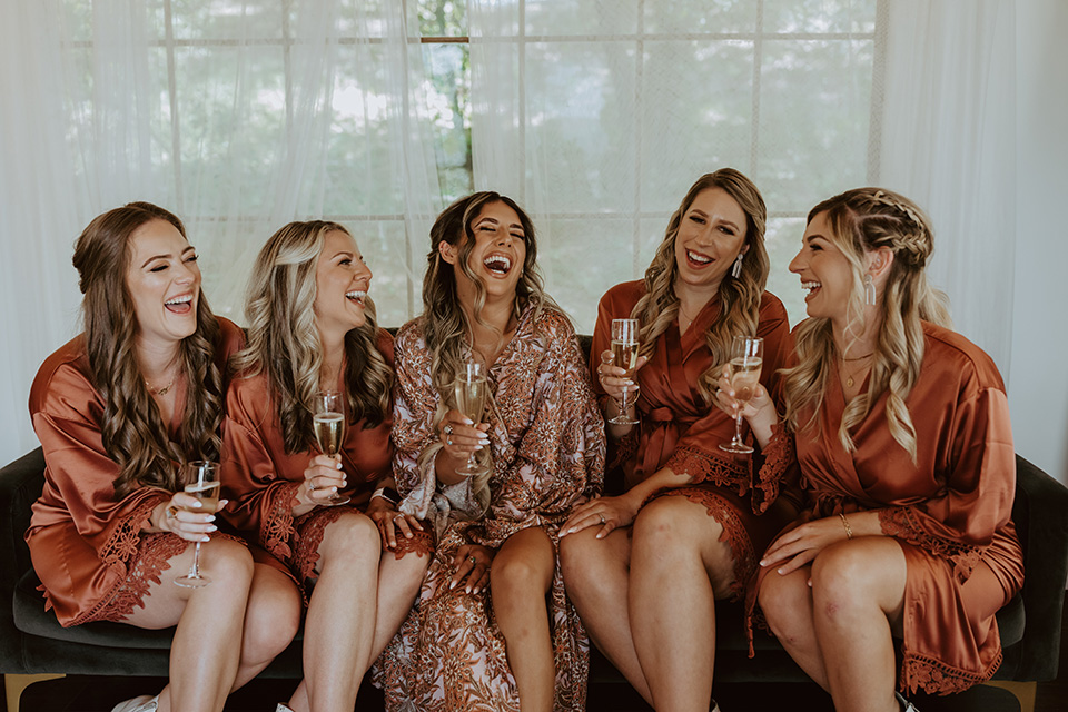  the bridesmaids in deep orange robes getting ready for the wedding 