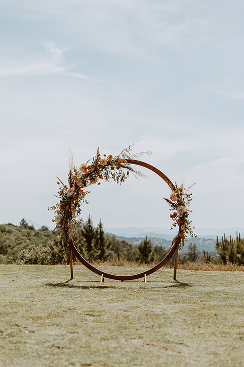  ceremony boho space with a circular wooden arch and dried florals  