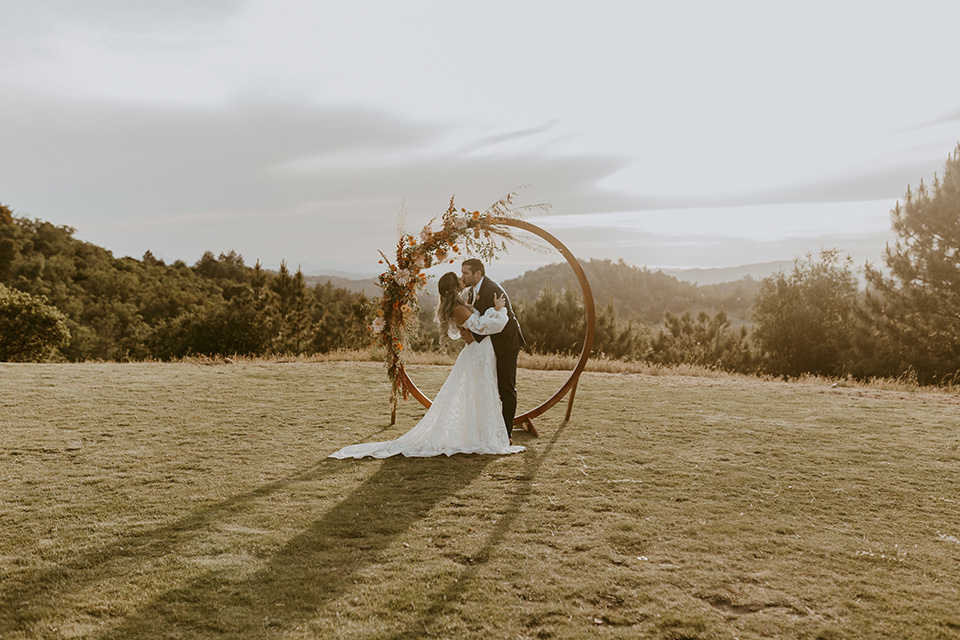  the bride in an ivory rue de sine gown and the groom in a dark blue suit with an orange tie at 