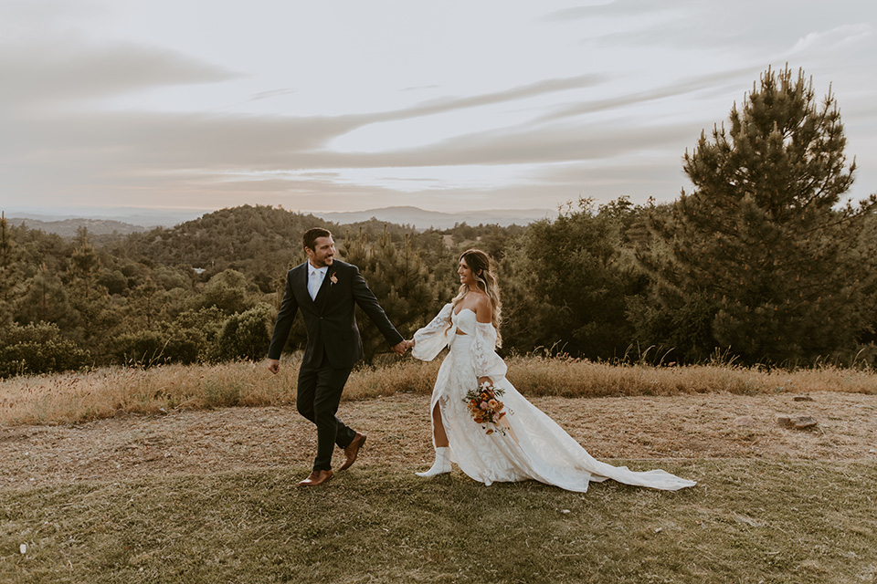  the bride in an ivory rue de sine gown and the groom in a dark blue suit with an orange tie at 