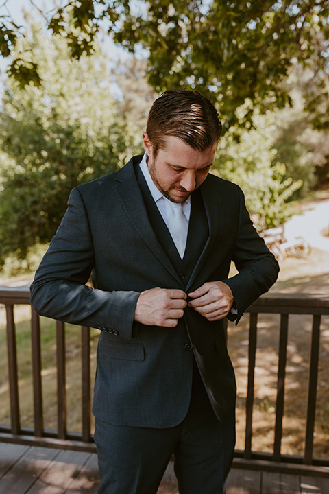  groom in a dark blue suit and orange long tie  