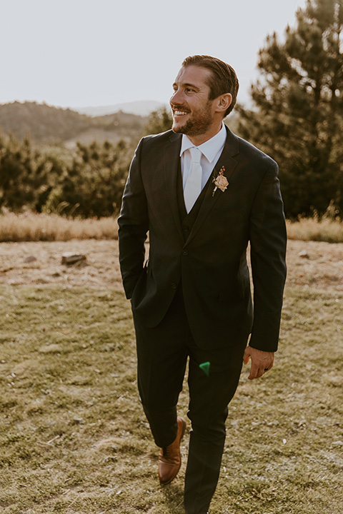  groom in a dark blue suit and orange long tie  