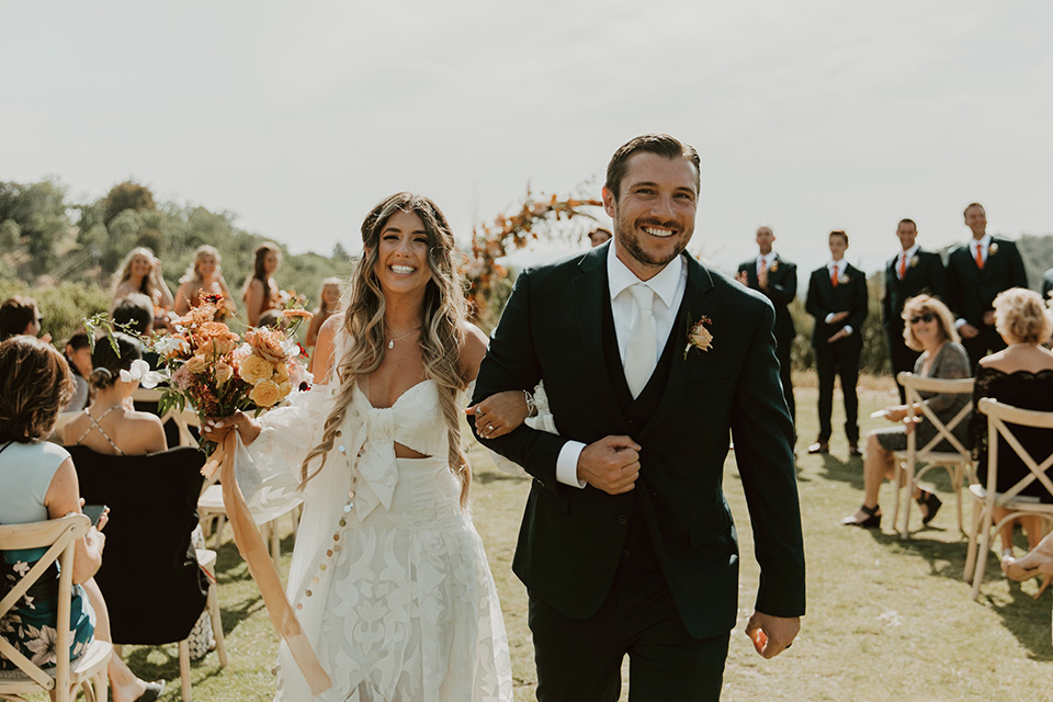  groom and groomsmen in dark blue suits with orange long ties 